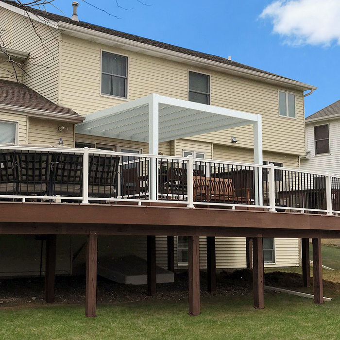 Picture of a white modern attached 2-post pergola providing shade for a 2nd story deck off of a pale yellow house