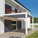 2-post white contemporary pergola attached to a modern-looking condo to provide shade over an outdoor patio area