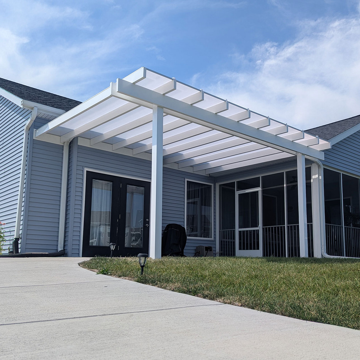 attached rainproof patio cover with a solid roof extending outward from a building