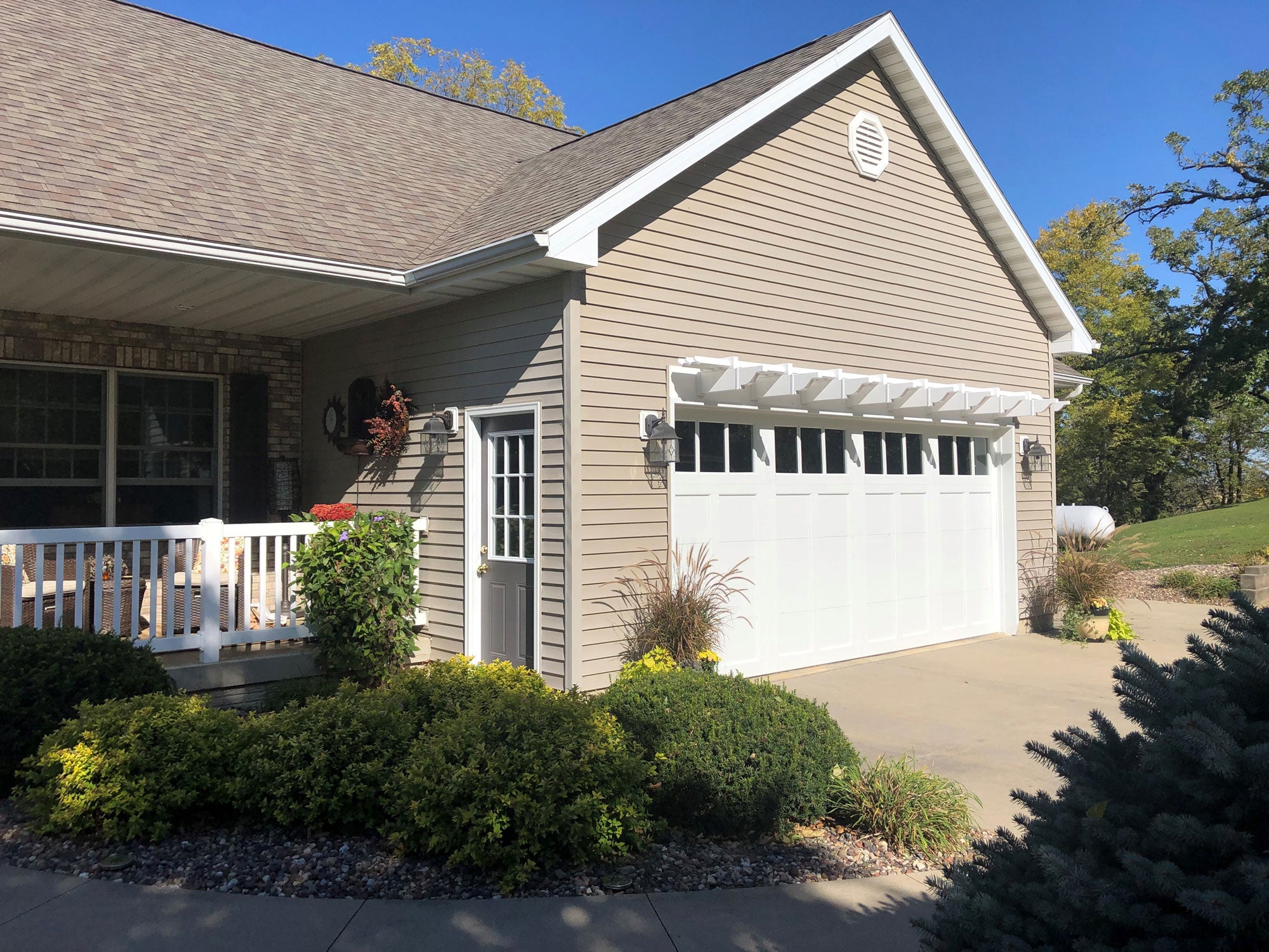 Decorative eyebrow pergola installed as an architectural accent on a building exterior