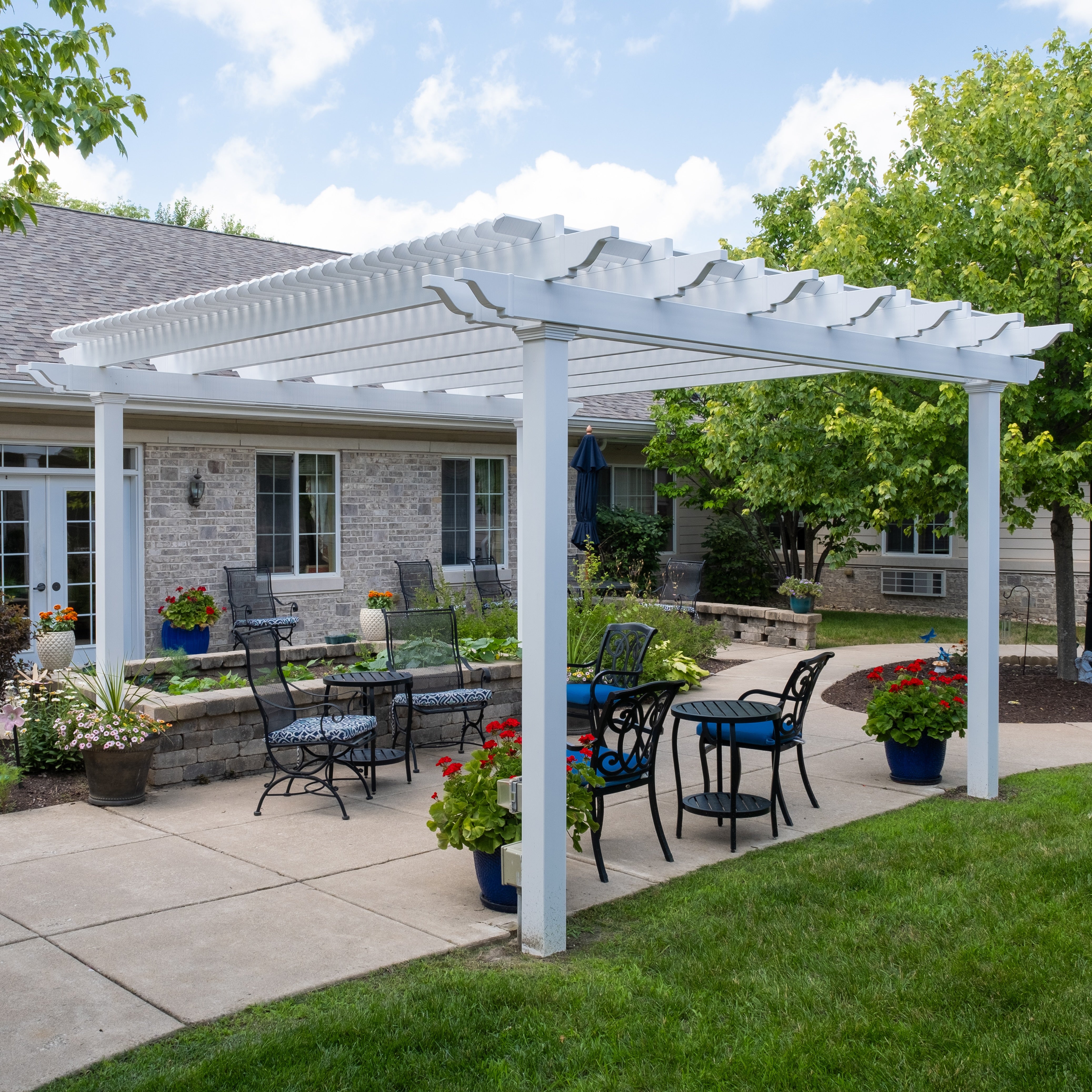 traditional freestanding pergola illustrating an outdoor furniture setting beneath a slatted roof