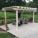 Picture of a tan vinyl free-standing traditional pergola with overhangs in the back yard of a home, with a dining table and chairs underneath the pergola