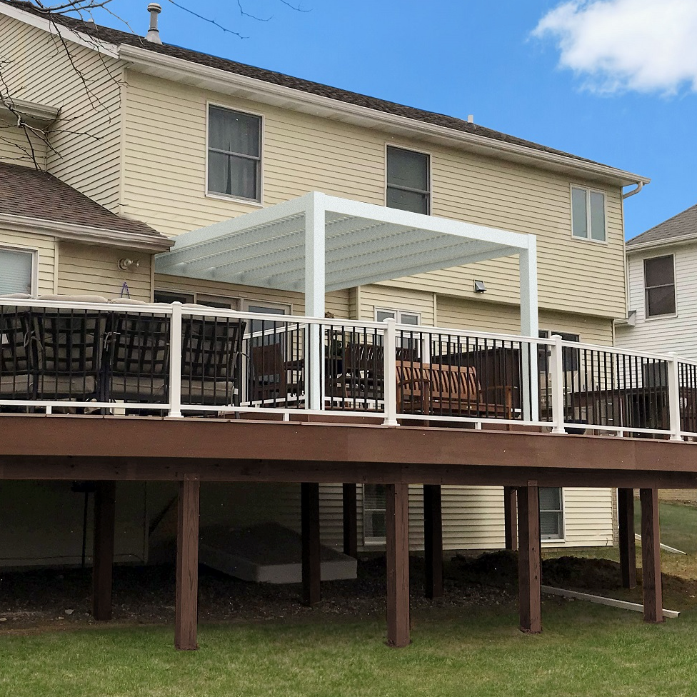 Picture of a white modern attached 2-post pergola providing shade for a 2nd story deck off of a pale yellow house