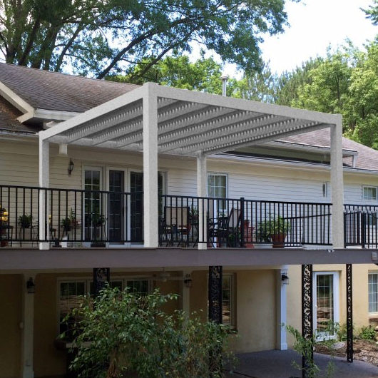 Picture of a 4-post contemporary-style pergola on a 2nd story deck with a circular metal staircase coming off the deck and several potted plants below