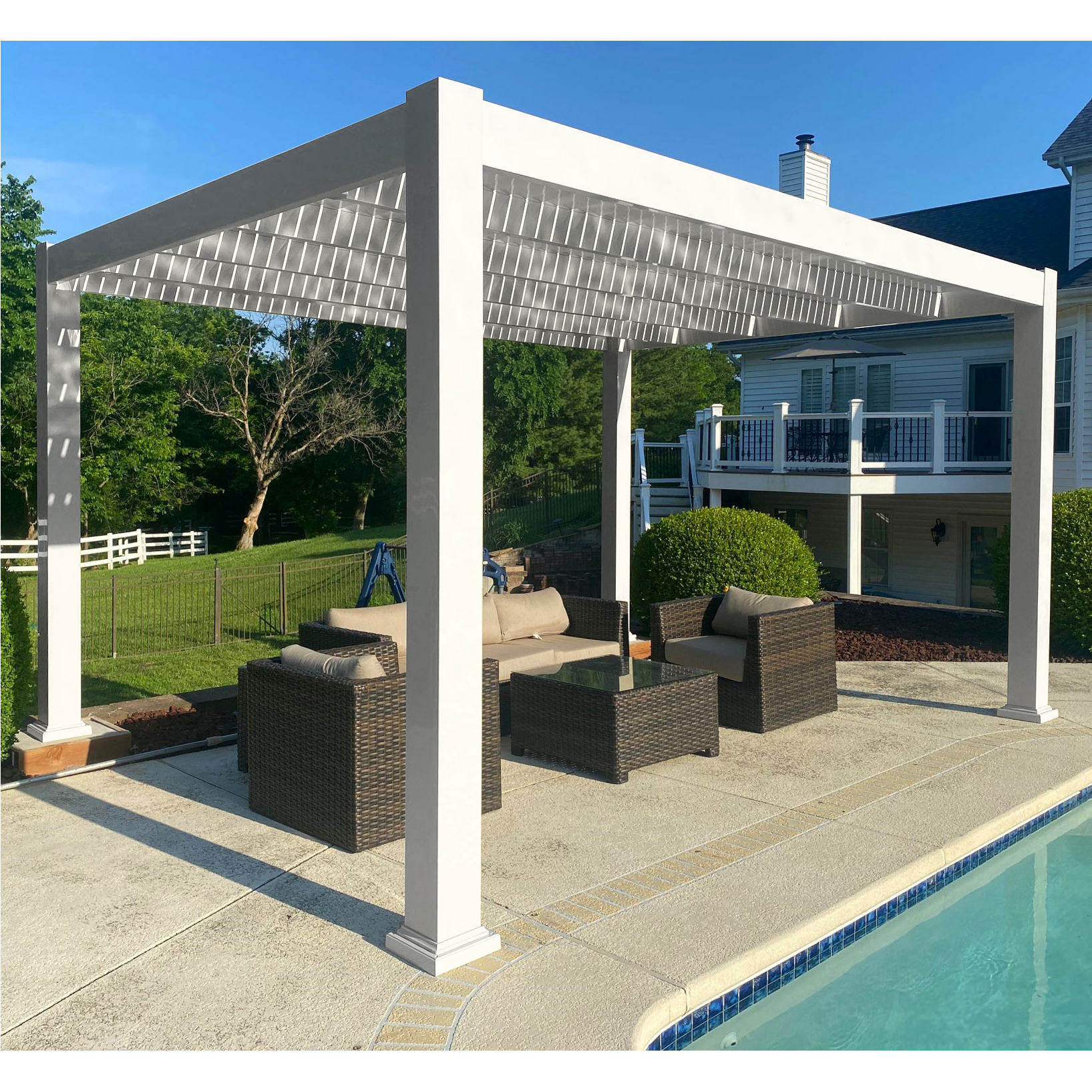 Picture of a white free-standing modern pergola over an outdoor patio dining set next to a pool