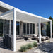 3-post white vinyl modern pergola attached to a contemporary condo providing shade for an outdoor patio area