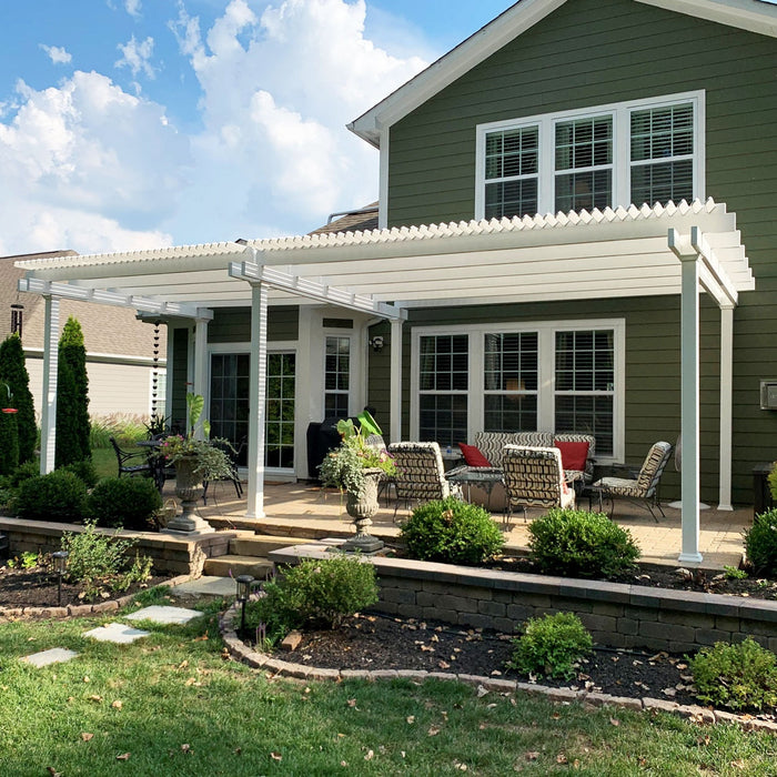 Traditional white free-standing 6-post pergola providing shade for the back deck behind a nice dark green house